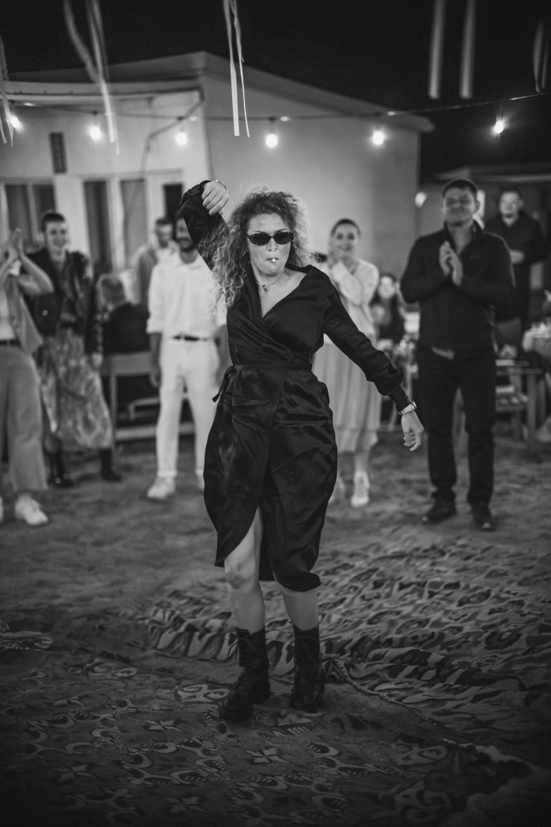 Черно-бяла снимка на танцуваща жена със слънчеви очила на сватбено парти | B&W photo of a woman dancing with sunglasses at a wedding party